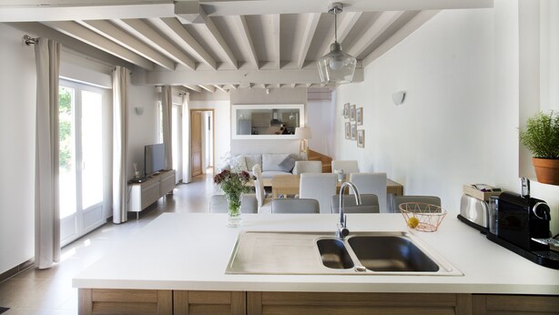 A modern kitchen with a large island, built-in appliances, and a view into the dining area. - L'OEUILLADE: calm and tranquility in Champagne (Œuilly)