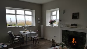 A dining area with a table set for four, a fireplace, and a view of the outdoors.