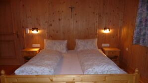 A wooden bed with two pillows and two bedside tables, each with a light.