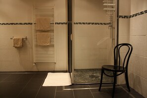 Een bad/douchecombinatie, een bubbelbad, een haardroger, handdoeken