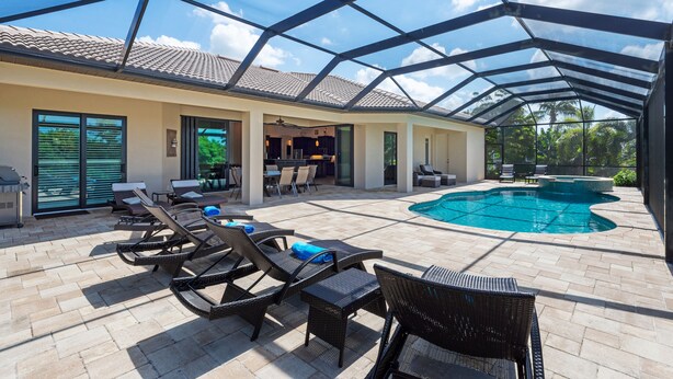An outdoor pool area with lounge chairs, a covered patio, and a view of the sky. - SW Cape Coral Waterfront Villa "Summerset" | Pool + Jacuzzi | south-facing | (Cape Coral)