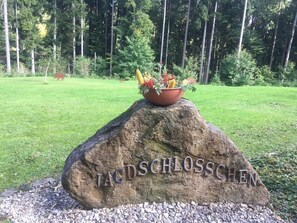 Una roca con la inscripción “TACDSCHLOSSCHEN” y una planta en maceta encima.