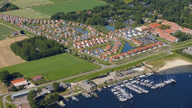 An aerial view of a coastal village with a marina, residential areas, and surrounding fields. - Corner house 3 bedrooms on the Grevelingen Sea in the park Aquadelta, free Wi-Fi (Bruinisse)