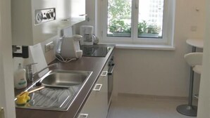 A modern kitchen with a large window, stainless steel appliances, and a clean, white interior. - Totally new apartment, central location, competitive price, WiFi, elevator (Wien)