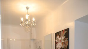 A clean, modern bathroom with a white vanity, a mirror, and a chandelier. - Totally new apartment, central location, competitive price, WiFi, elevator (Wien)