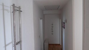 A hallway with wooden flooring, white walls, and a metal structure on the left. - Apartment at St. James, amidst the nature park Südeifel, on the edge of Islek (Lascheid)