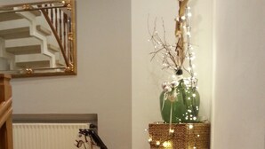 Un escalier orné d’une statuette de cheval décorative, d’un ornement en forme d’étoile et d’un vase vert illuminé.