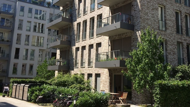 A multi-story residential building with balconies, a bike rack, and a small outdoor seating area. - Luxury apartment in the trendy district of Berlin Mitte (Berlin)