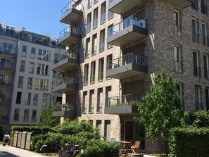 A multi-story residential building with balconies, a bike rack, and a small outdoor seating area. - Luxury apartment in the trendy district of Berlin Mitte (Berlin)