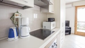 A modern kitchen with a built-in stove, a coffee maker, and a microwave. - Apartment with air conditioning, sea view, swimming pool, Wi-Fi, quiet hill, parking. (Toscolano Maderno)
