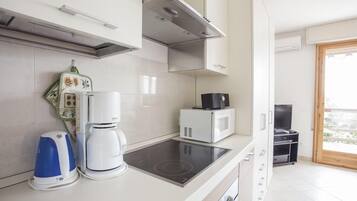 A modern kitchen with a built-in stove, a coffee maker, and a microwave.