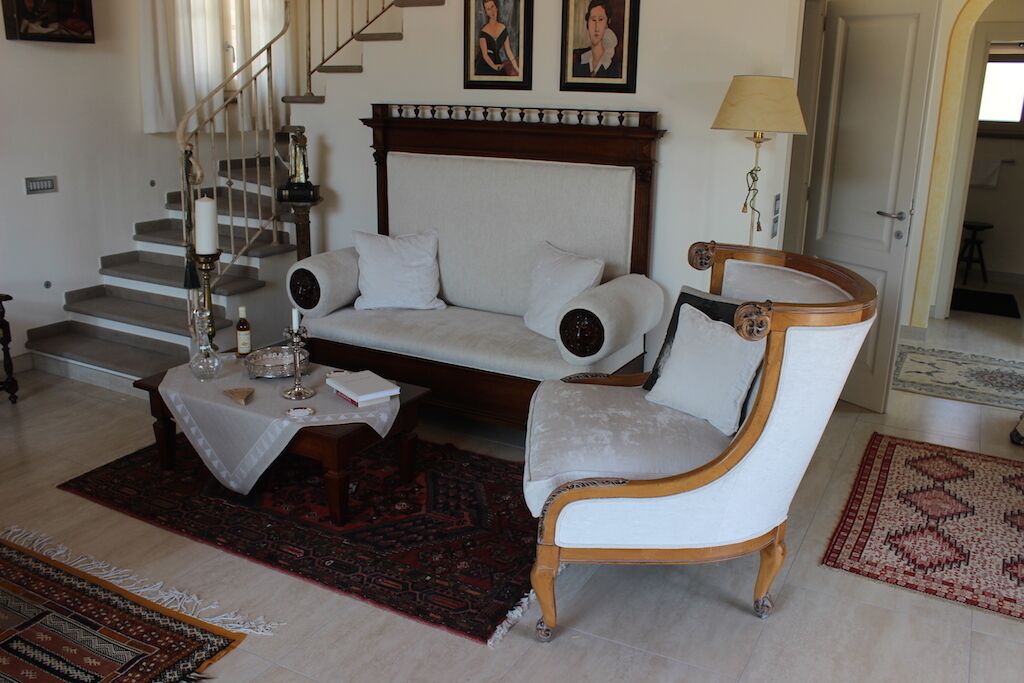 Un salon comprenant un canapé, un fauteuil, une table basse et un escalier.