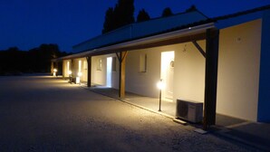 Ein Gebäude mit mehreren überdachten Außenbereichen, jeweils mit Beleuchtung.