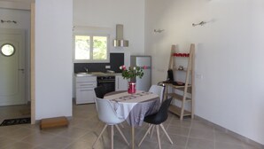 Eine moderne Küche mit Einbauofen, Kühlschrank und einer Essecke mit Tisch und Stühlen.