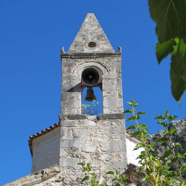 A bell tower with a clear blue sky in the background. - Spacious, family friendly ground floor apartment with large garden near the sea (Stoupa)