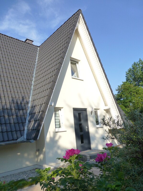 Ein Haus mit einem steilen Dach, einem kleinen Fenster und einer Tür.