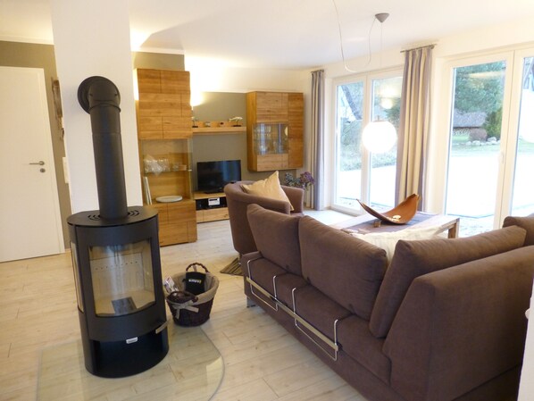A modern living room with a sofa, a fireplace, and a television.