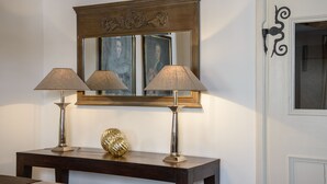 Une console en bois, agrémentée de deux lampes et d’un objet décoratif.