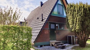 A house with a sloped roof, a chimney, and a front door. - Family-friendly holiday house with large garden and great features (Butjadingen-Burhave)