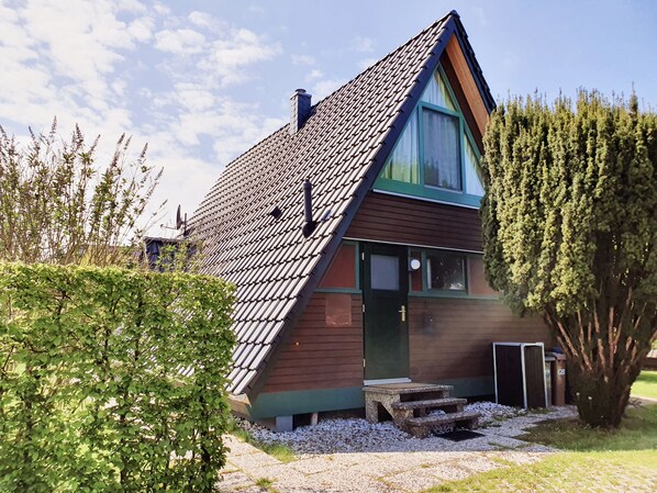 A house with a sloped roof, a chimney, and a front door.