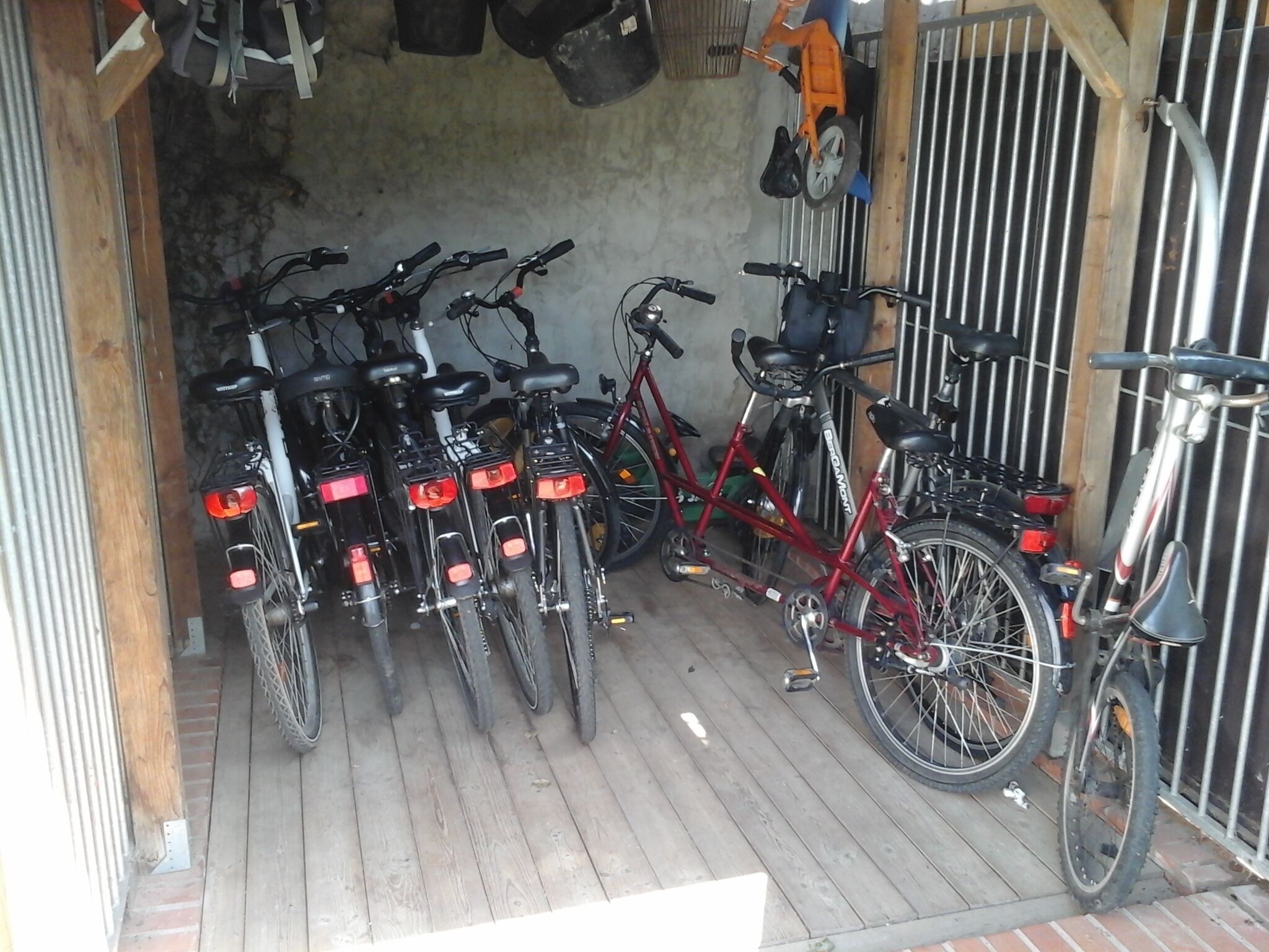 A covered bicycle parking area with multiple bicycles parked.