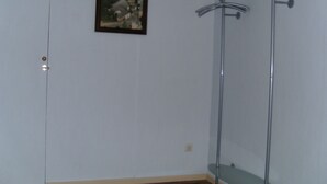 A bathroom with a glass shower enclosure, a door, and a framed picture on the wall. - Holiday in a quiet location (Nideggen)