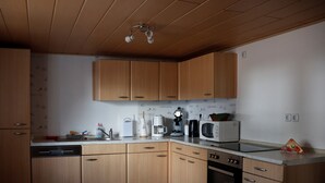 A kitchen with wooden cabinets, a microwave, a coffee maker, and a dishwasher. - Holiday in a quiet location (Nideggen)