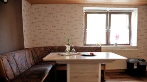 A cozy room with a wooden bench, a table, and a window with a view. - Holiday in a quiet location (Nideggen)
