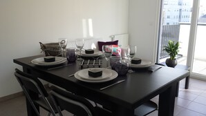 A dining table set for four with plates, glasses, and cutlery.
