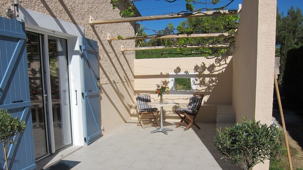 A patio with a table and two chairs, a blue gate, and potted plants. - Cosy studio 2 pers.,  parking,  2 terraces,  wifi (Laroque-Des-Albères)