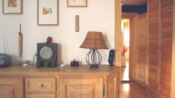Ein Holzkapuzenbad mit Schubladen, ein Radio, eine Lampe und gerahmte Bilder an der Wand.