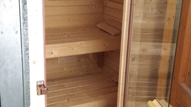 Un intérieur en bois, une porte en verre, un loquet en métal et une poignée en métal.