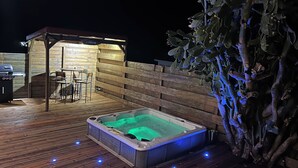 A hot tub on a wooden deck with a wooden fence and a small bar area in the background. - Villa Bois Jolan in Saint-Anne, Guadeloupe (Sainte-Anne)