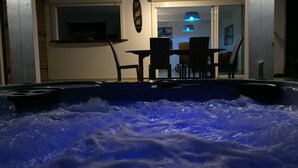 A hot tub with a table and chairs in a room with a ceiling fan and a window. - Villa Bois Jolan in Saint-Anne, Guadeloupe (Sainte-Anne)