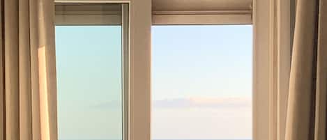 A balcony with a view of the sea and rocky shoreline.