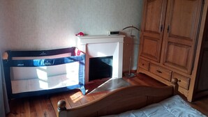Una camera da letto con un letto in legno, un caminetto bianco, un armadio in legno e un trampolino.