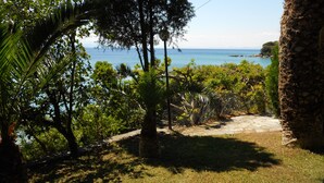 Un jardin en bord de mer, avec un sentier de pierres qui mène à un point de vue sur l’océan.