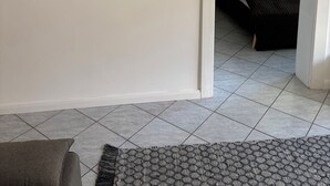 A room with a bed, a painting of flowers on the wall, and a rug on the floor. - tastefully furnished & quiet apartment in West Lichterfelde (Berlin)