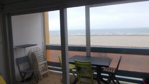 Une chambre avec vue sur la plage, une table et des chaises.