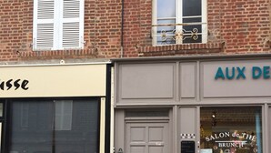 A storefront with a closed shutter, a door, and a window displaying items. - BEAUTIFUL APARTMENT 2 STEPS FROM THE BEACH / NEAR TO THE BEACH! (Étretat)