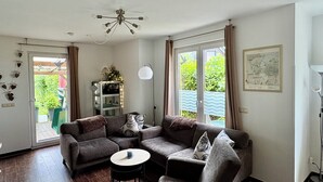 Ein Wohnzimmer mit einem Ecksofa, einem runden Couchtisch und einem Deckenventilator.