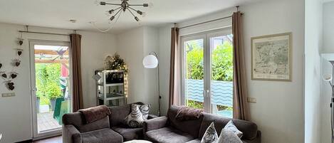 A living room with a sectional sofa, a round coffee table, and a ceiling fan.