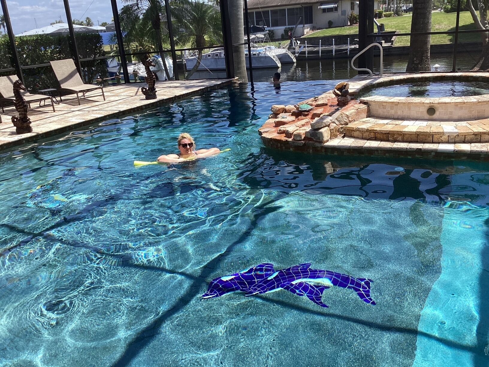 Une piscine à l’eau claire, des chaises longues et un îlot décoratif.
