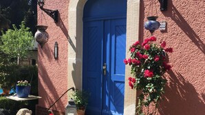 A building with a blue door, potted plants, and two lion statues.