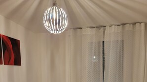 A room with two wooden beds, white bedding, a small wooden nightstand with a lamp, a red carpet, and a large window with sheer curtains. - Away from the city life and yet part of the action (Appenweier)