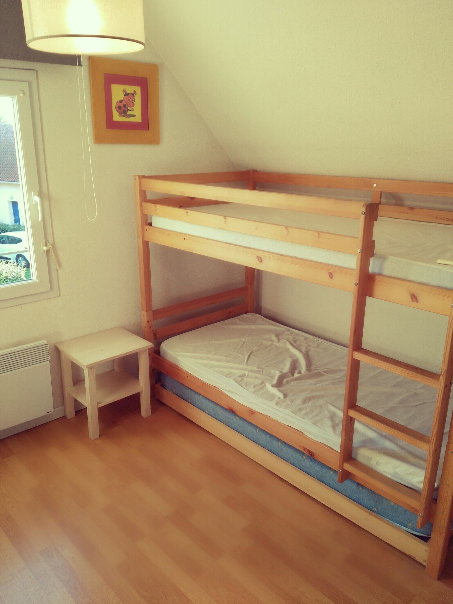 Et værelse med køjeseng, et lille bord og en radiator.