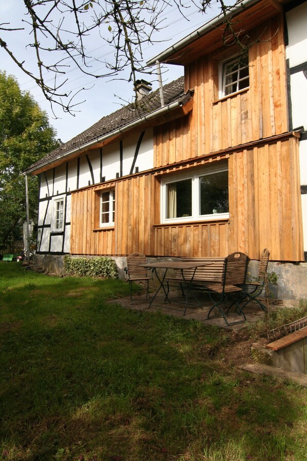 A wooden house with a garden bench and a small table. - Beautiful house in country style in the Bergisch Land (Ruppichteroth)