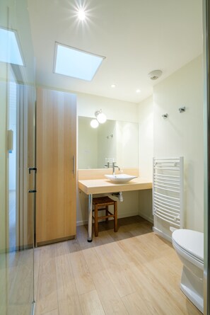 A modern bathroom with a wooden vanity, a white sink, and a white toilet. - Pretty recent house, any comfort, in peace, in 500 m of the beach and the port. (Jard-Sur-Mer)