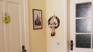 A hallway with two doors, one with a 'Willkommen' sign and a picture, and the other with a frosted glass window. - Apartment 'Am Poeler Tor' in the old town of Wismar (Wismar)