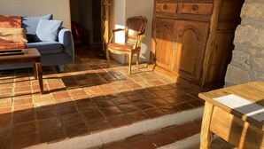 A cozy room with a blue sofa, a wooden chair, and a wooden cabinet. - Rest and nature in Menton, sea and private pool. Pet-friendly. (castellar)
